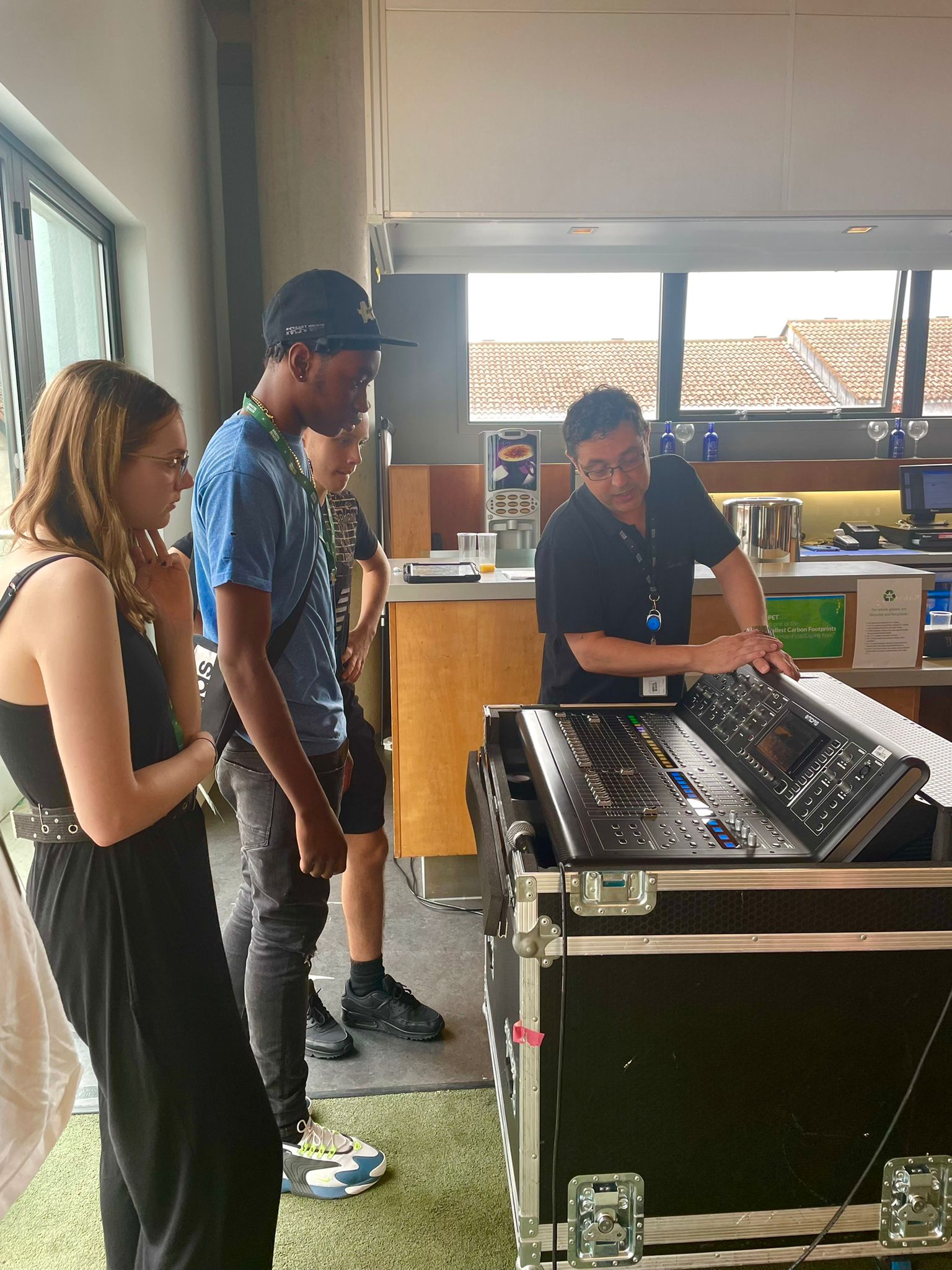 Students being taught to use a sound desk by a technician